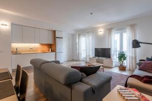 a living room with a couch and a kitchen at Hellenhost - Gran Vía in Madrid