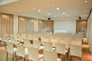 an empty room with white chairs and tables at Le Parc Hotel & Suite in Villa María +12 photos