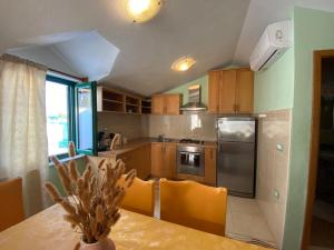 a kitchen with wooden cabinets and a table with a dining room at Apartments Linda in Drasnice
