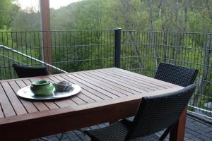 una mesa de madera con dos tazas en el balcón en FeWo Waldblick, en Rieden
