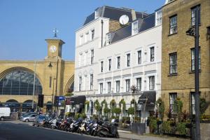 a row of motorcycles parked in front of buildings with a clock tower at Kings Cross Inn Hotel in London