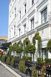a white building with plants on the side of it at Kings Cross Inn Hotel in London