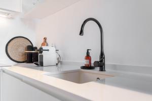 um balcão de cozinha com um lavatório e uma torneira em Hellenhost - Gran Vía em Madri