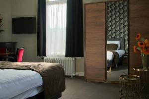 een hotelkamer met een bed en een spiegel bij De Roode Leeuw Terborg in Terborg