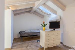 - une chambre avec un lit et une télévision sur une commode dans l'établissement Appartamento Villa Principessa, à Arco