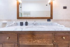 un baño con lavabo y espejo en Appartamento Ania vista castello, en Tenno 37 fotos más