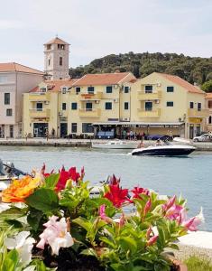 a boat in a body of water with flowers at Apartments Luna in Tisno