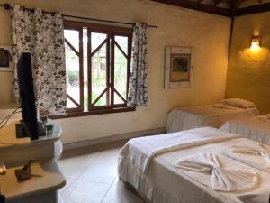 sypialnia z 2 łóżkami i oknem w obiekcie Pousada Baobá w mieście Juquei