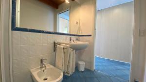 a white bathroom with a sink and a mirror at Bellavista di Magarà in Cefalù +35 photos
