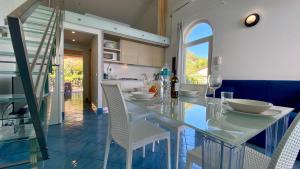 a dining room with a glass table and chairs at Bellavista di Magarà in Cefalù