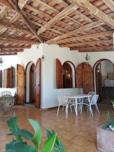 a dining room with a table and chairs and wooden ceilings at Verde & Mare in Palmi