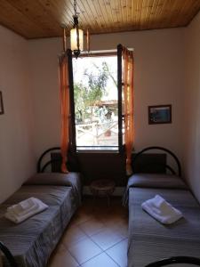 two beds in a room with a window at Verde & Mare in Palmi