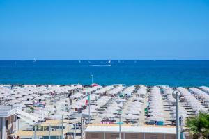 a beach with a lot of umbrellas and the ocean at Hotel Baby in Rimini