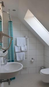 a white bathroom with a sink and a toilet at Südhotel in Paderborn