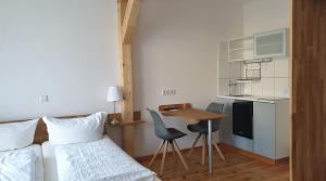 a bedroom with a bed and a table and a kitchen at Südhotel in Paderborn