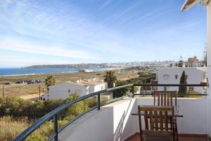 balcón con 2 sillas y vistas al océano en Apartamento Meia Praia, en Lagos