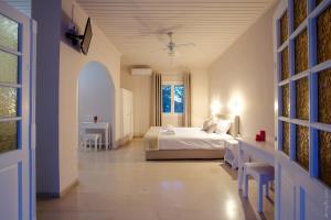 ein Schlafzimmer mit einem weißen Bett und einem Fenster in der Unterkunft Paradise Village in Roda