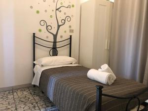 1 dormitorio con 1 cama con un árbol en la pared en Night & Day, en Pisa