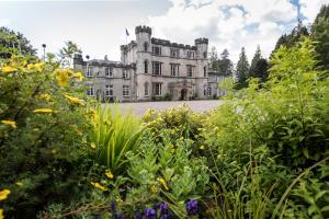 an old castle with a garden in front of it at Melville Castle Hotel in Edinburgh