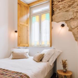 a bed in a room with a window at Casa da Tia Zézinha by RNvillage in Sesimbra