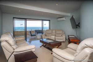 un soggiorno arredato con vista sull'oceano di Lazy Lizard 41 - with Inverter a Umdloti