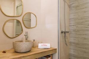 a bathroom with a sink and mirrors on the wall at Casa da Tia Zézinha by RNvillage in Sesimbra +25 photos