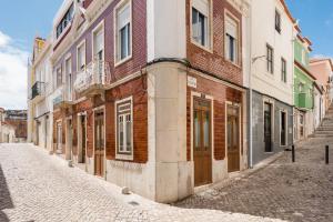 an empty street in an old town with buildings at Casa da Tia Zézinha by RNvillage in Sesimbra