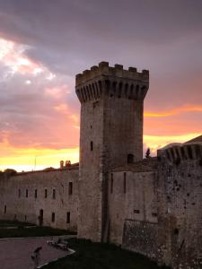 an old castle with a sunset in the background at Torre della Botonta in Castel Ritaldi