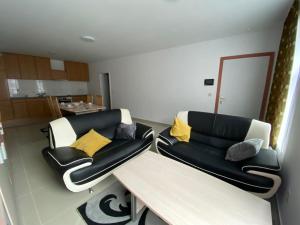 sala de estar con 2 sillas y sofá en Luxe appart, en Dison