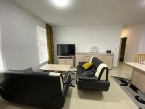 sala de estar con 2 sillas y mesa en Luxe appart, en Dison