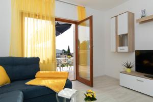 a living room with a blue couch and a television at Apartments Tonica in Malinska