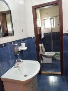 La salle de bains est pourvue d'un lavabo, de toilettes et d'un miroir. dans l'établissement Lucy Guest House (B&B), à Addis-Abeba