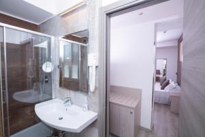La salle de bains est pourvue d'un lavabo et d'une douche. dans l'établissement Hotel Baby, à Rimini