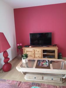 een woonkamer met een flatscreen-tv aan de muur bij Logement douillet neuf L'INDIAN in Dossenheim-sur-Zinsel