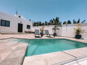 a swimming pool in front of a house at La Palma Luxury in Las Ledas