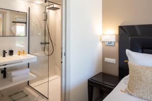 a bathroom with a shower and a sink and a mirror at Hotel Don Cesar in Porto-Vecchio