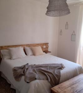 Un dormitorio con una cama blanca con una manta. en Casa Cucun, en Saluzzo