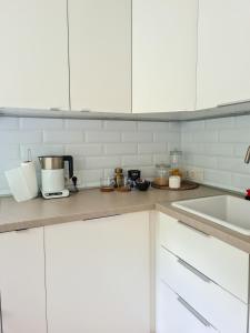 a kitchen with white cabinets and a counter top at Old Town Vytautas Apartment in Klaipėda +8 photos