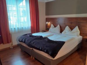 a bedroom with a large bed with white sheets at Gasthof Brauerei Kofler in Rottenmann