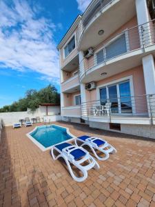 un patio con tumbonas y una piscina en Villa Luciana, en Trogir