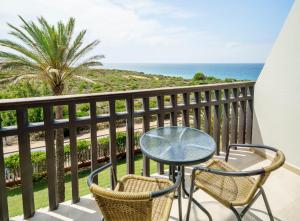 a table and two chairs on a balcony with the ocean at Ilunion Calas de Conil in Conil de la Frontera