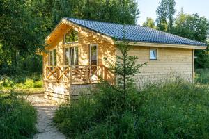 a small house in the middle of a field at Гостевые дома у Ладоги in Priladozhskoye