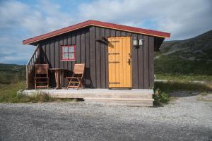 Cabaña pequeña con mesa y 2 sillas en Davvi Siida - Reindeer Design Lodge, en Kjøllefjord