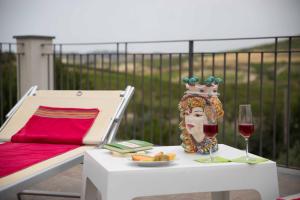 a table with a vase and a glass of wine at Agriturismo Alpa in Mazzarino