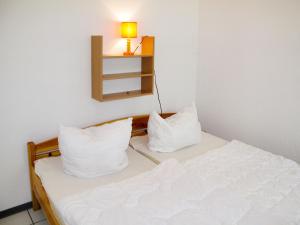 ヒンメルプフォルトにあるHoliday Home Waldhäuser-2 by Interhomeのベッド1台(枕2つ、壁にランプ付)