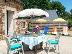 プルーアにあるHoliday Home Le Petit Nice - PHA103 by Interhomeの庭にテーブルと椅子、傘