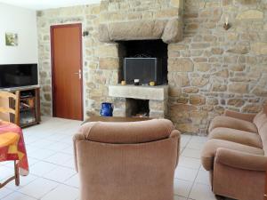 a living room with two chairs and a stone fireplace at Holiday Home Ty Kerzo - PHM100 by Interhome in Plouhinec