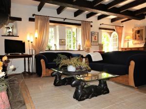 ein Wohnzimmer mit einer schwarzen Couch und einem Tisch in der Unterkunft Holiday Home Dolce Vita by Interhome in Plouha