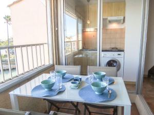 聖普里安海灘的住宿－Apartment Marina Village-2 by Interhome，厨房里配有蓝色餐具的白色桌子