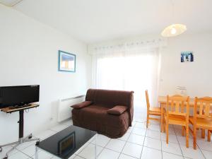 a living room with a couch and a table and a television at Studio PORT SUD by Interhome in Capbreton